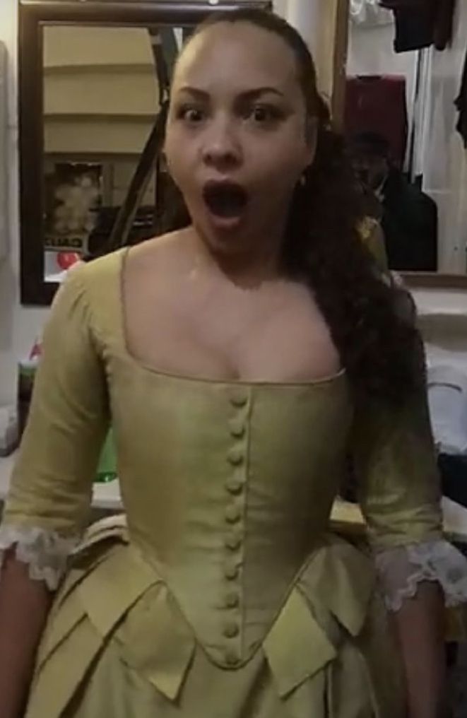 a woman in a yellow dress making a surprised face