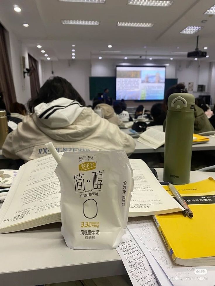 a bag of coffee sitting on top of a table next to papers and a pen