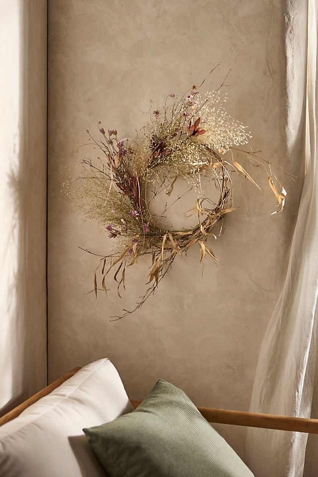 a wreath hanging on the wall above a bed