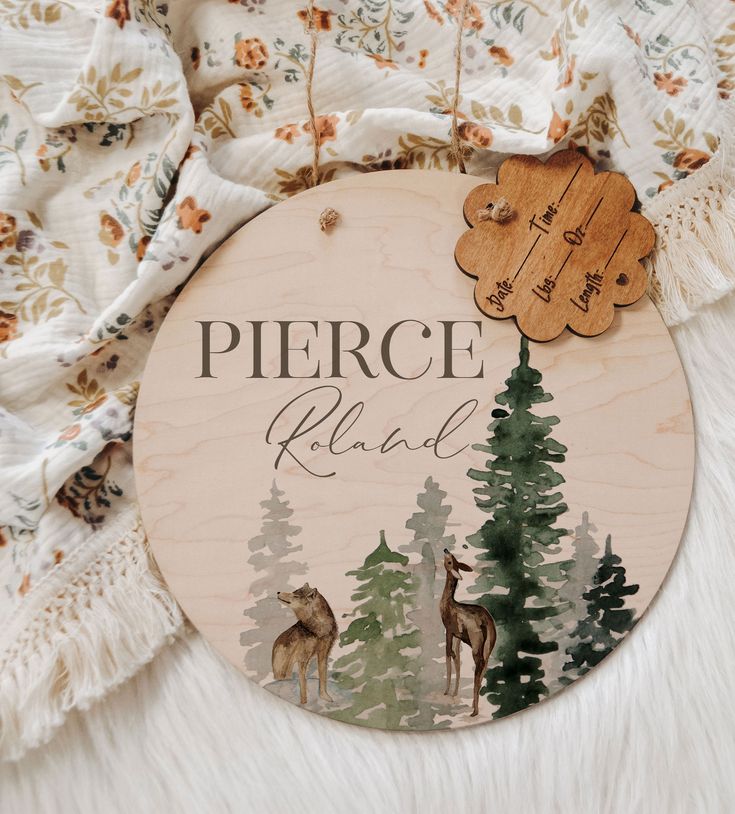 a wooden sign that says pierce island with deer and pine trees in the background on a white furnishing