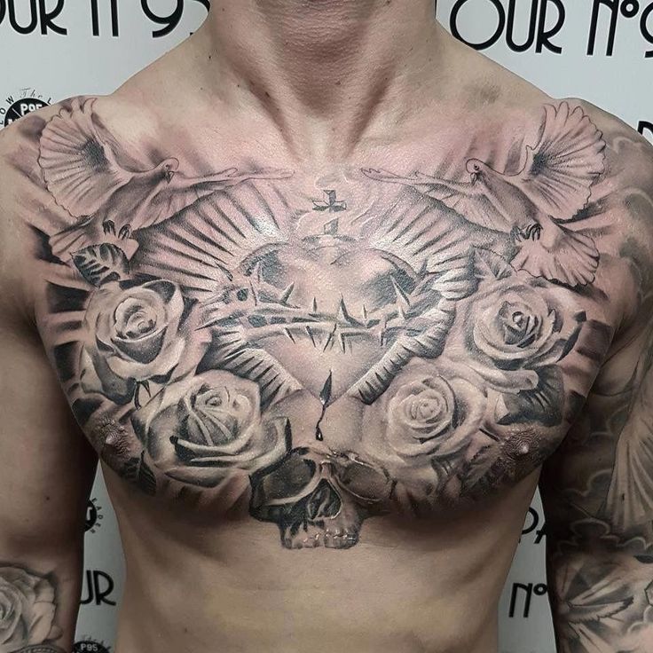 a man with tattoos on his chest has roses and a cross in front of him