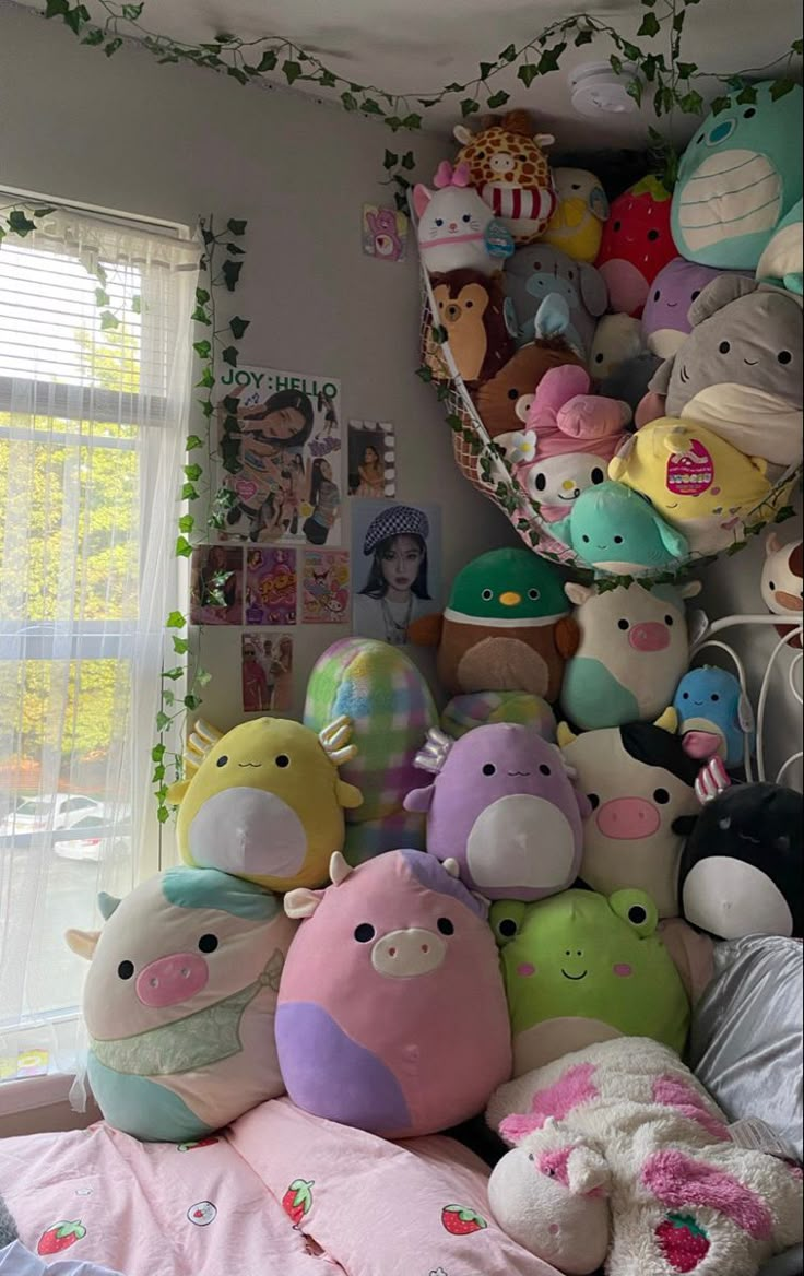 a pile of stuffed animals sitting on top of a bed