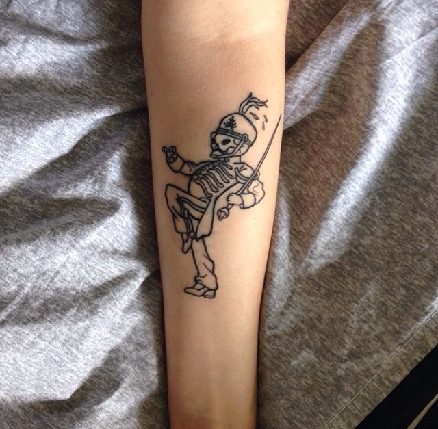 a person with a tattoo on their arm holding a baseball bat and wearing a glove