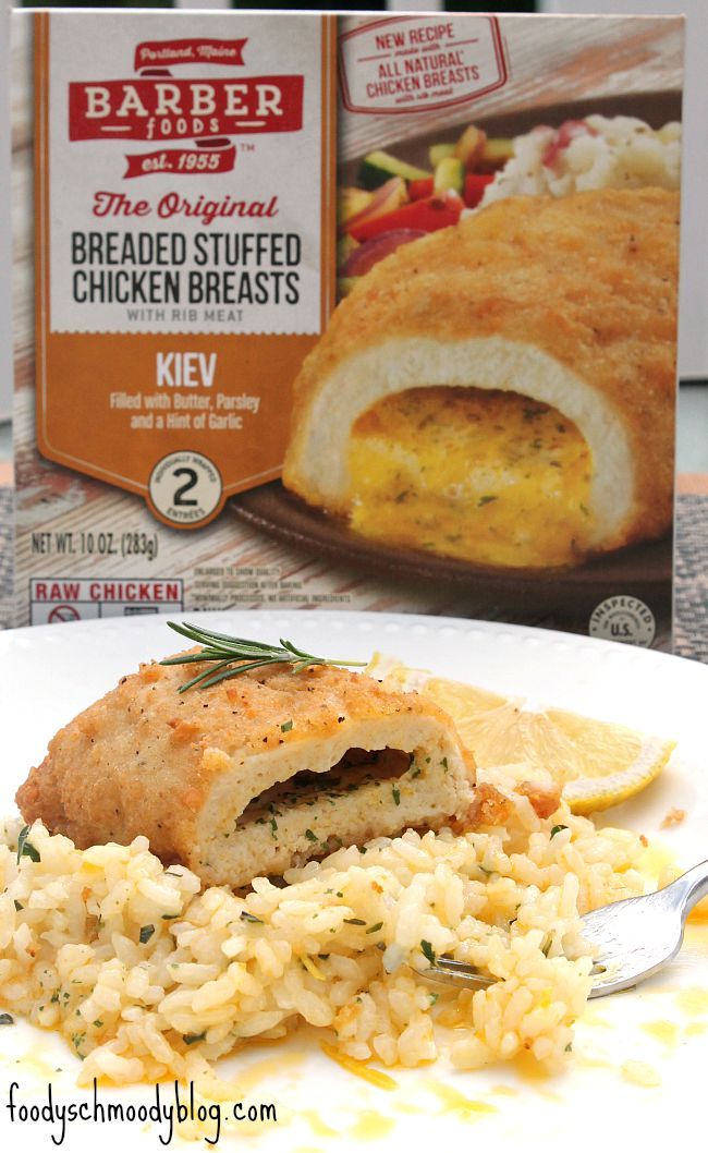 a white plate topped with chicken and rice next to a box of breaded stuff