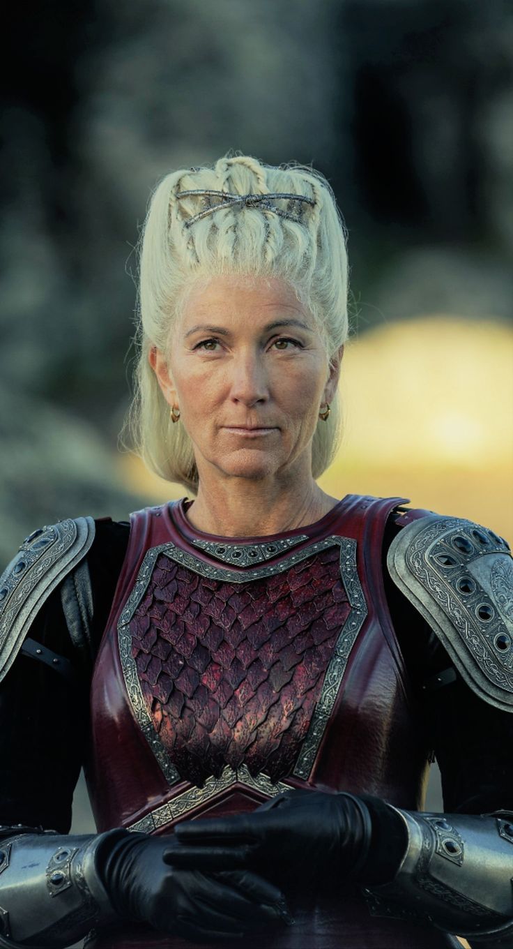 an older woman with blonde hair wearing armor