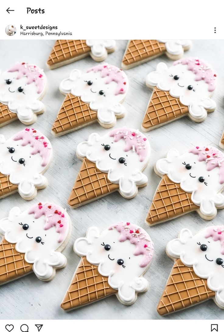 decorated cookies in the shape of ice cream cones are arranged on a table with pink and white icing