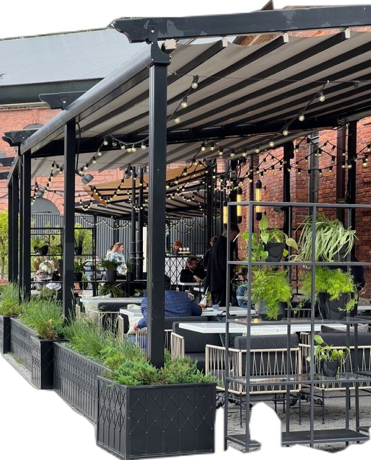 an outdoor dining area with tables, chairs and potted plants on the outside patio