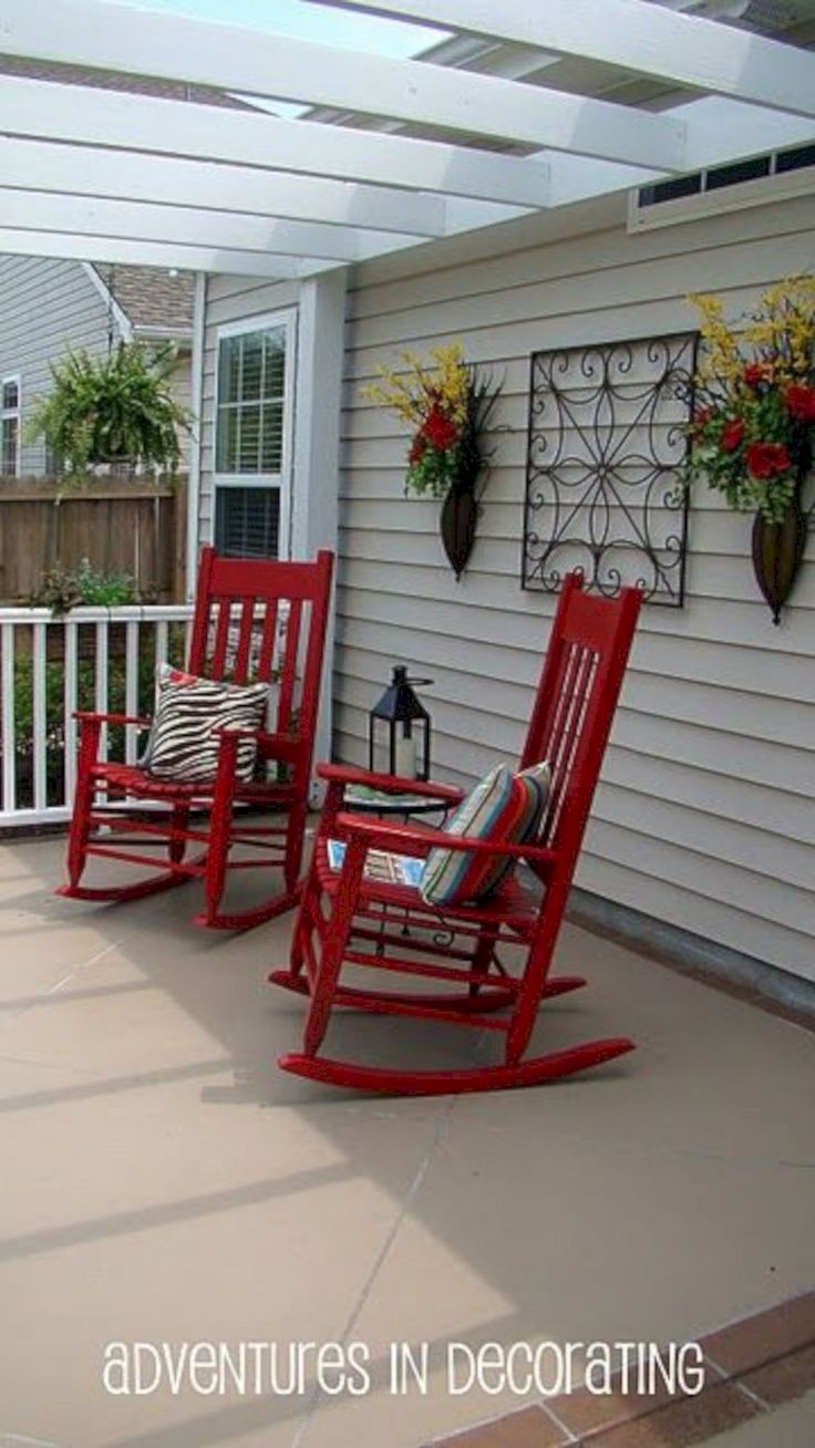 two red rocking chairs sitting on top of a patio