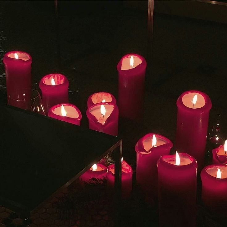 many lit candles are arranged on the floor in front of a black table and mirror