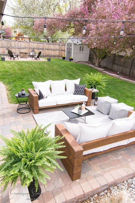 an outdoor living area with couches, tables and potted plants on the patio