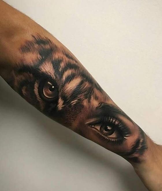 a man's arm with a tiger face on it and an eye in the middle