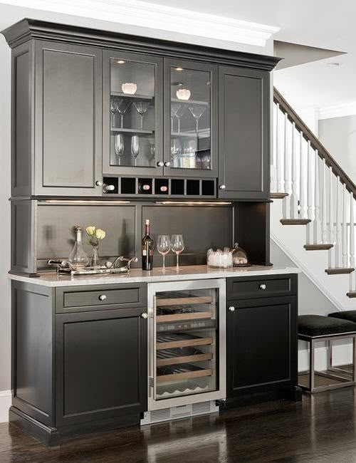 a kitchen with black cabinets and white stairs