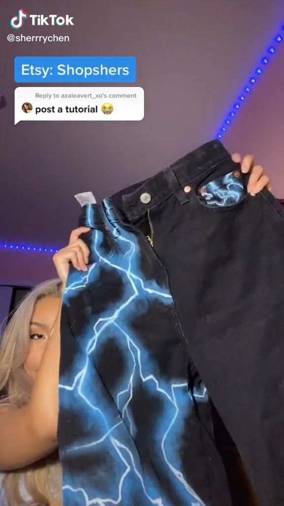 a woman is holding up a pair of black jeans with lightning print on it and the caption says, easy shoppers