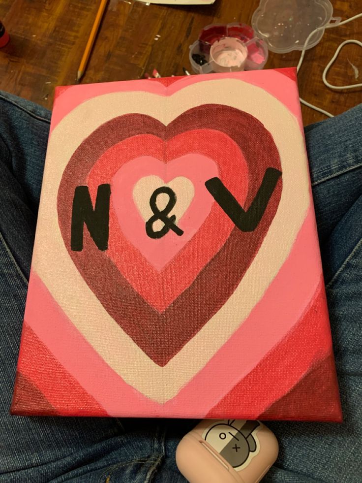 a heart painted on canvas with the initials n and v