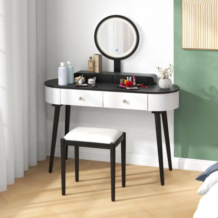 a white vanity table with a mirror and stool in front of it on a hard wood floor