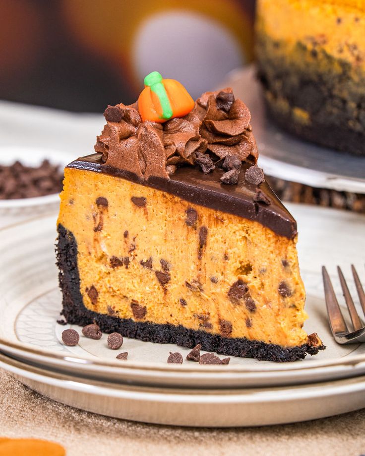 a slice of pumpkin cheesecake on a plate with chocolate chips and candy in the middle