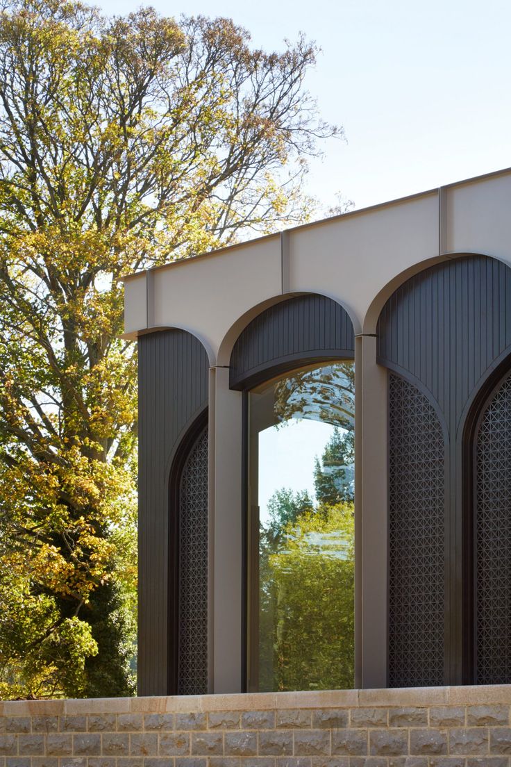 an arched window reflecting trees in the background