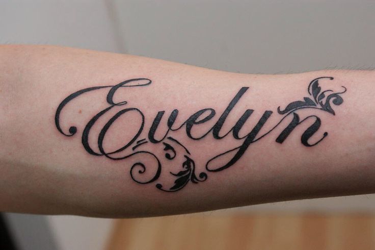 a person with a tattoo on their arm and the word evelyn written in cursive writing