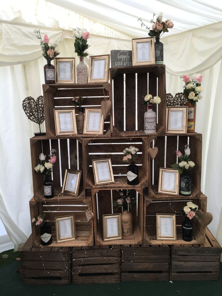 an arrangement of wooden crates with frames and flowers on them, all arranged in the shape of a stack