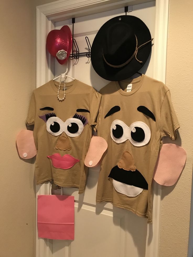 two t - shirts that have faces on them hanging from a door with a hat