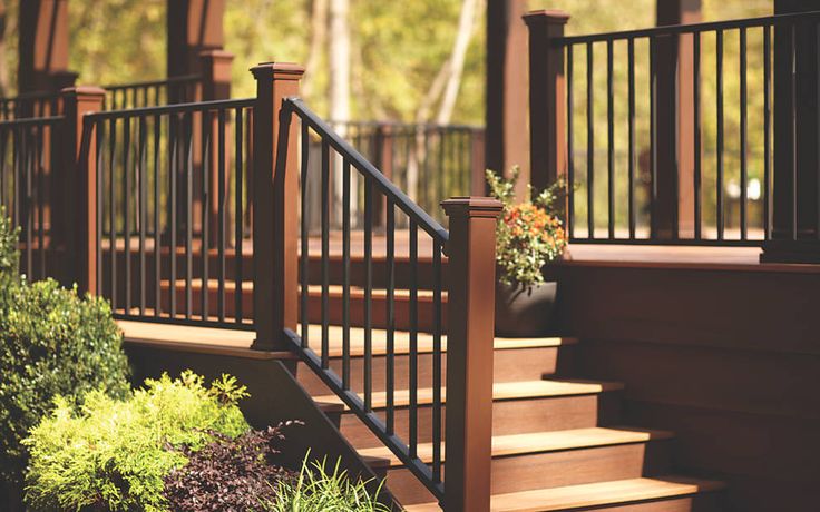 a wooden deck with railing and planters on it