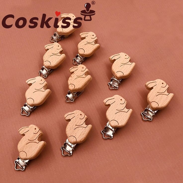 wooden keychain shaped like rabbits on a pink background with the words coskiss