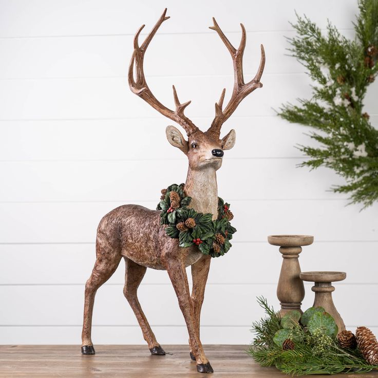 a statue of a deer standing on top of a wooden table next to pine cones