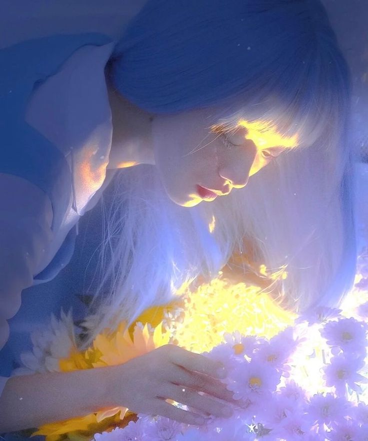 a woman with white hair and blue eyes is surrounded by flowers in her hands, looking down at the ground