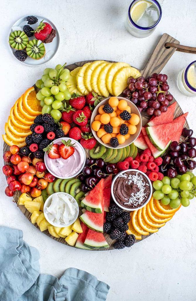 an assortment of fruits arranged on a cutting board