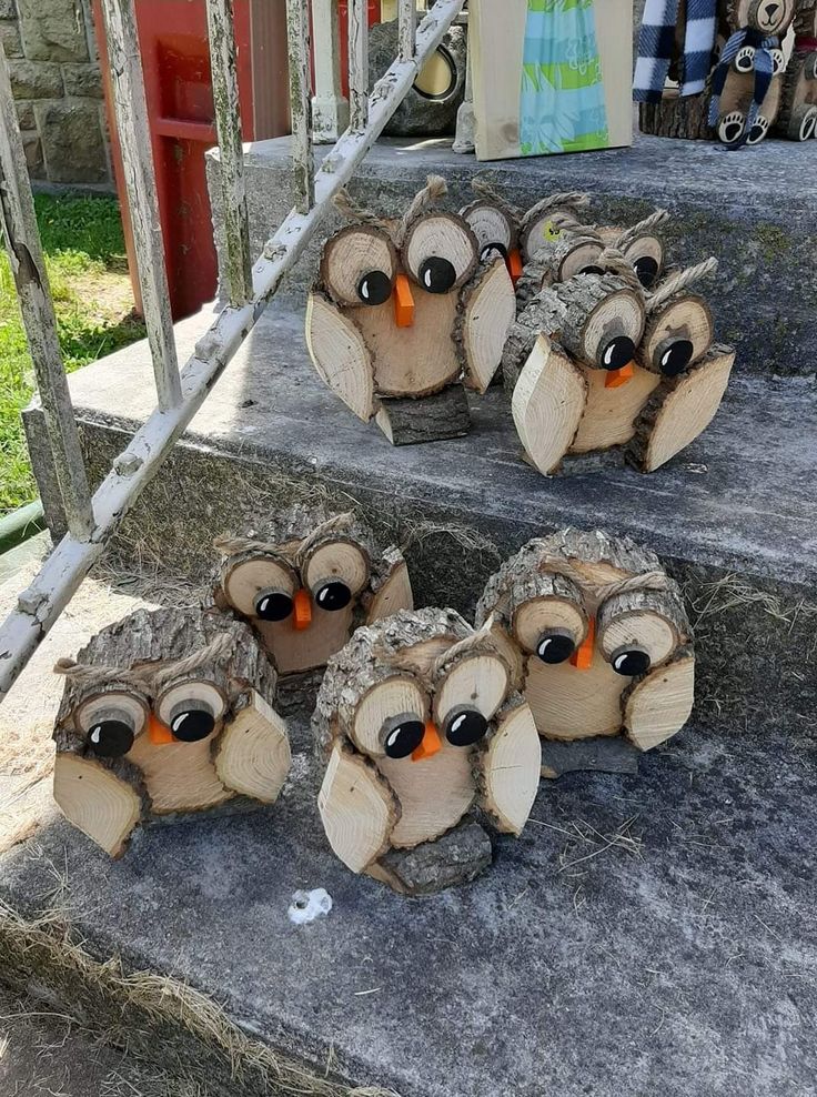 several carved wood owls sitting on the steps