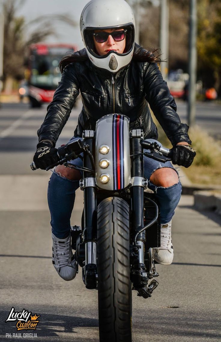 a man riding on the back of a motorcycle down a street