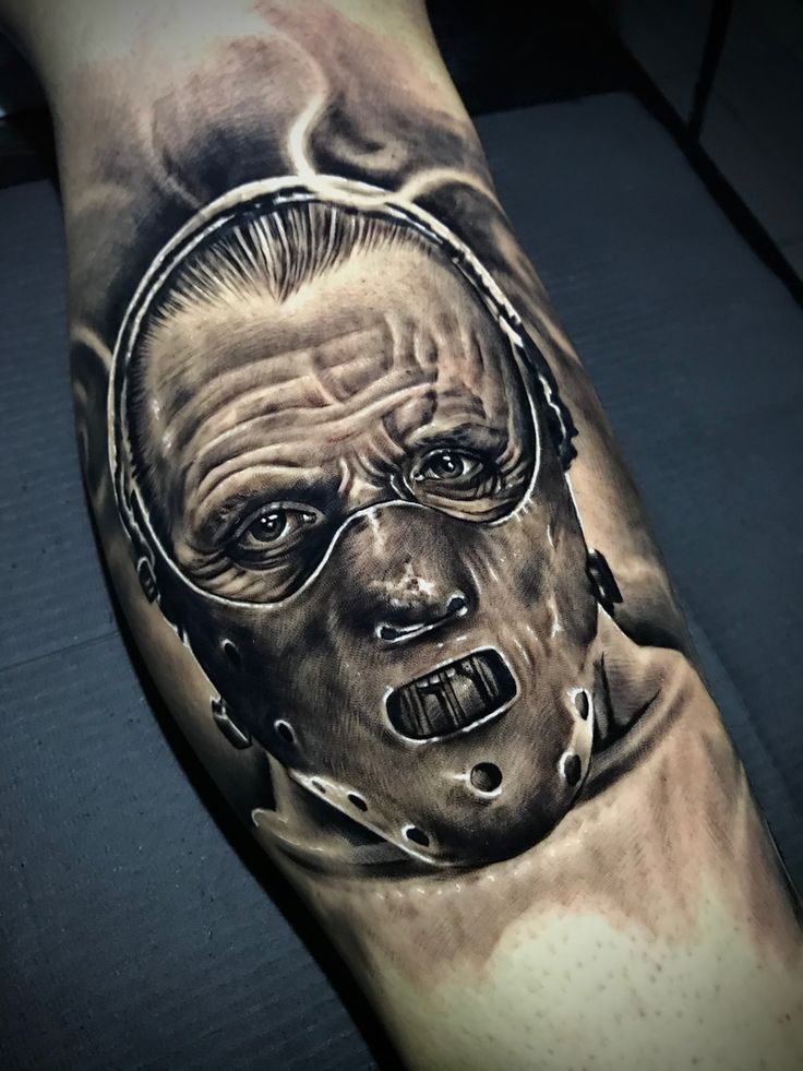 a man's arm with a tattoo on it that looks like he is wearing a mask