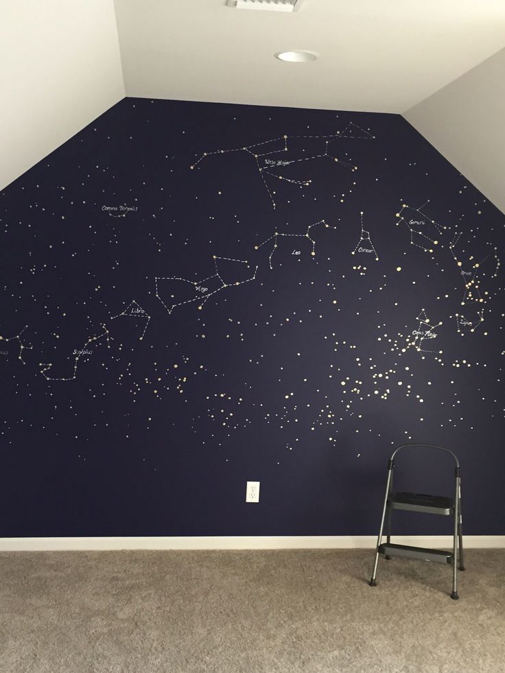 an empty room with a ladder in front of the wall and stars painted on it