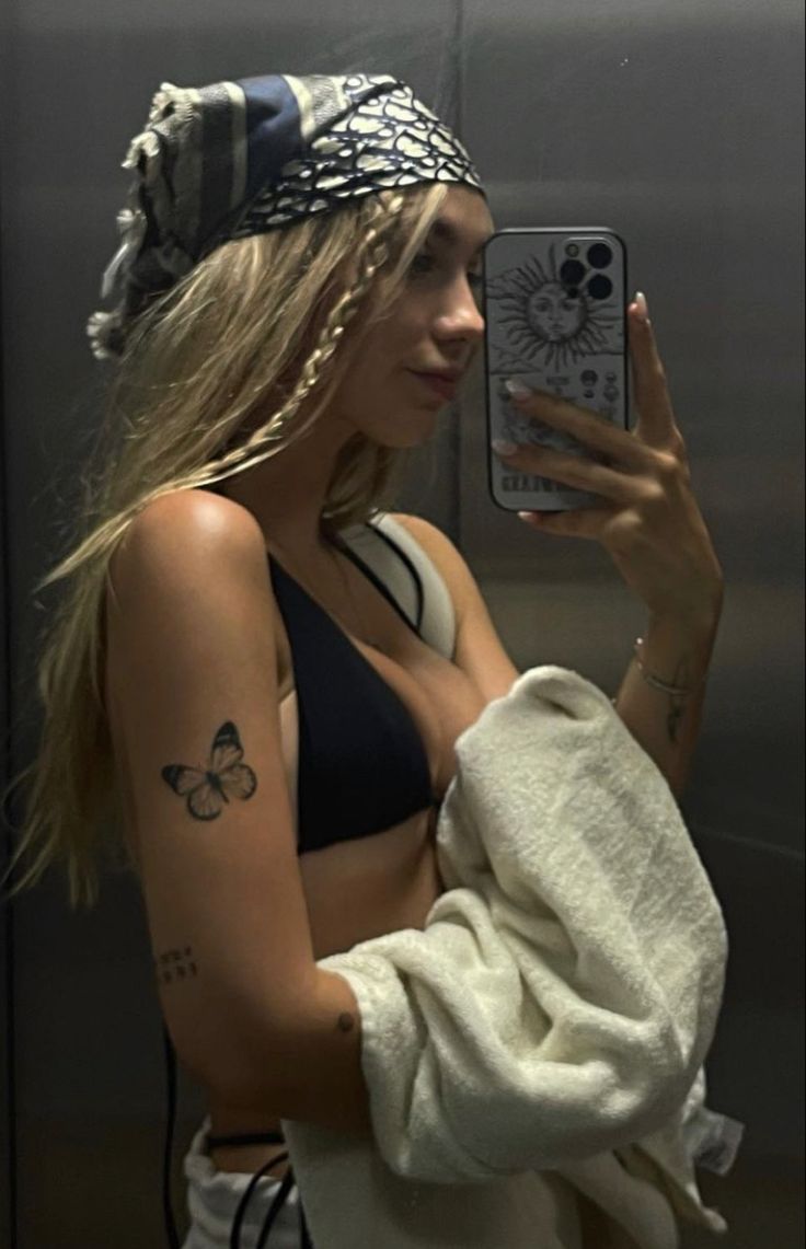 a woman taking a selfie in the mirror with her cell phone and towel over her shoulder