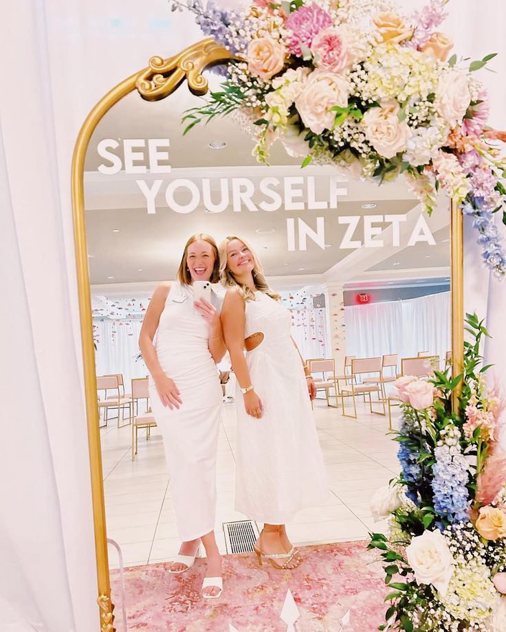 two women standing in front of a mirror that says see yourself in zeba on it