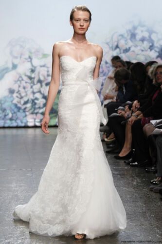 a woman in a wedding dress walking down the runway