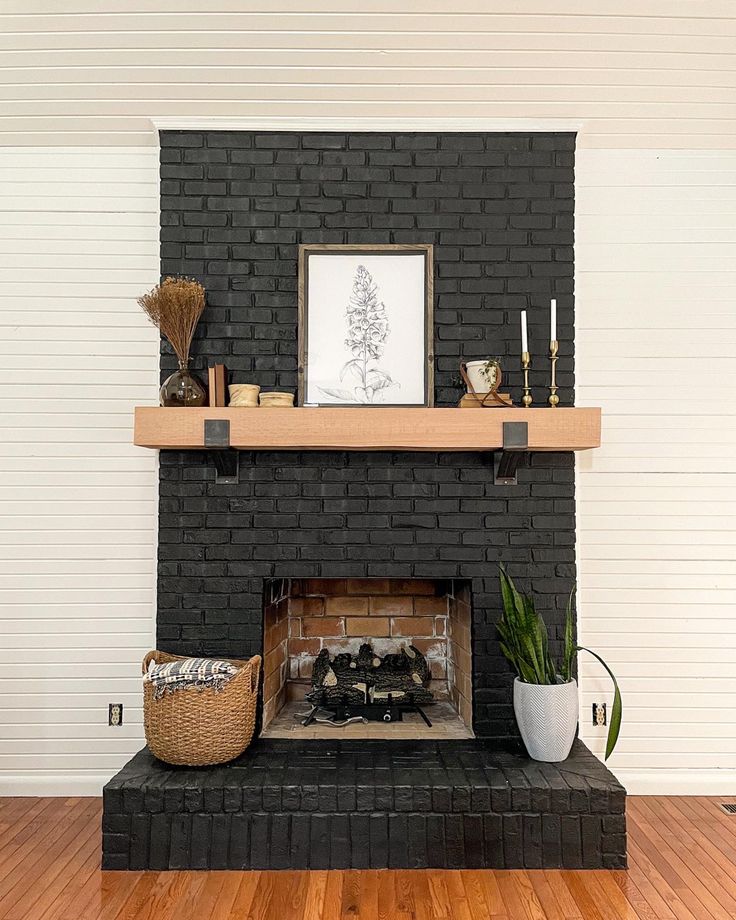 a living room with a brick fireplace and potted plants on top of the mantle