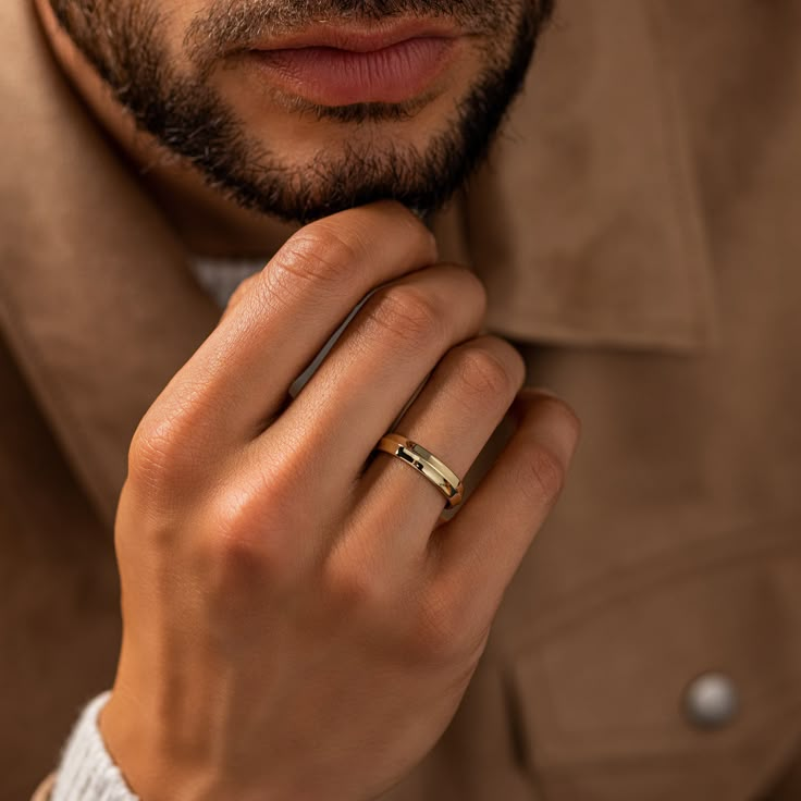 a man wearing a gold ring and jacket