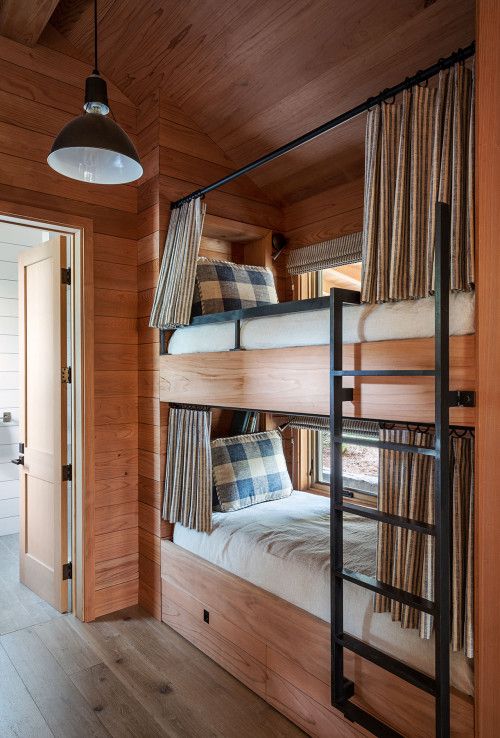 bunk beds are lined up against the wooden walls in this bedroom with wood flooring