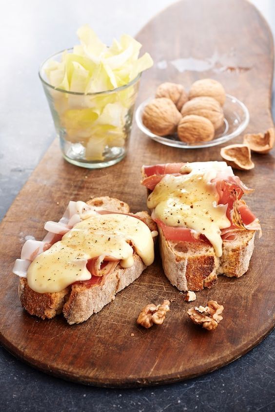 a wooden cutting board topped with two sandwiches