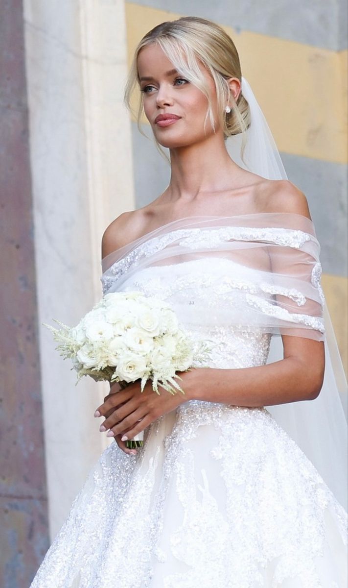 a woman in a wedding dress holding a bouquet