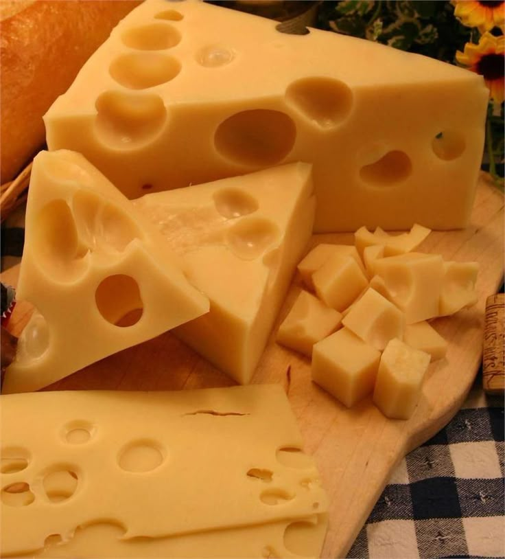 several pieces of cheese on a cutting board