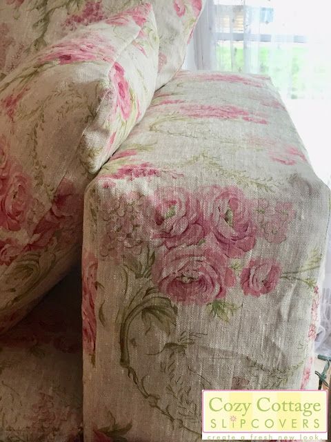 a couch with pink flowers on it in front of a window and the words cozy cottage