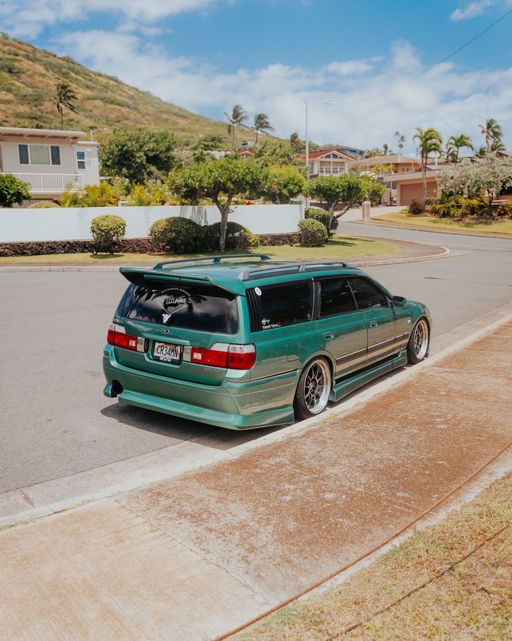 a green van is parked on the side of the road