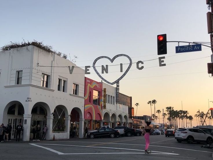 a woman crossing the street in front of a building with a heart cut out on it