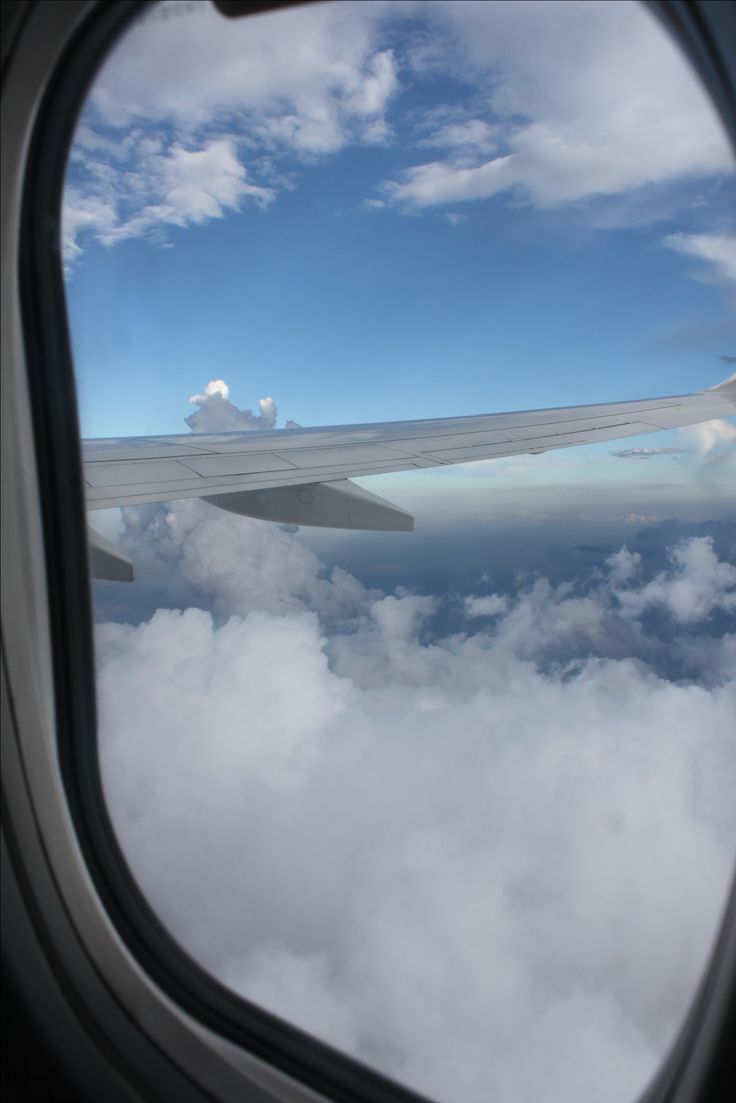 an airplane window looking out at the clouds