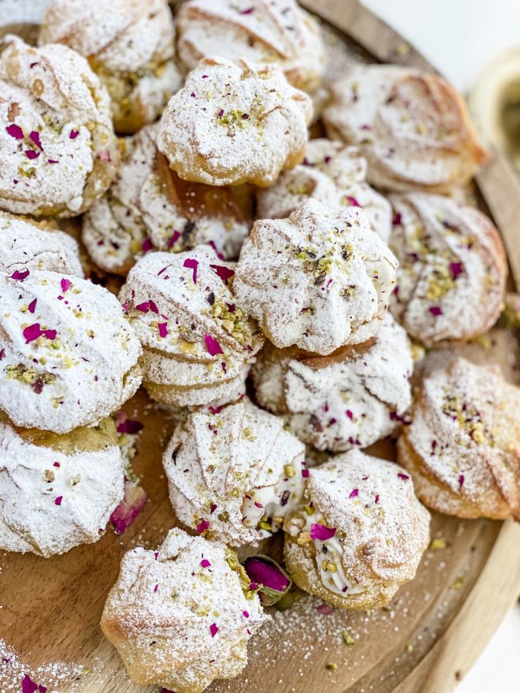 a wooden platter filled with powdered sugar covered pastries