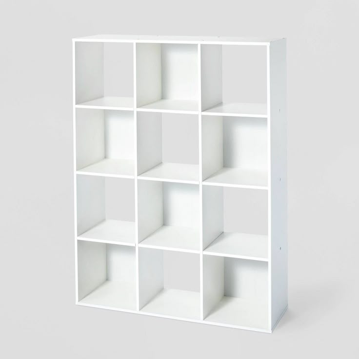 a white bookcase with twelve cubes on each side and one section missing from the top