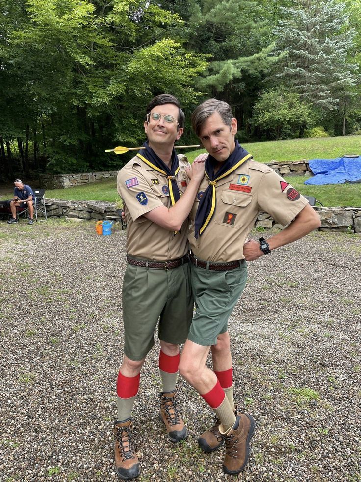 two men in scout uniforms standing next to each other with their arms around each other