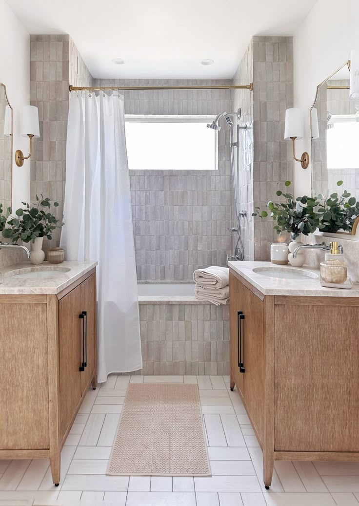 a bathroom with white tile and wood cabinets